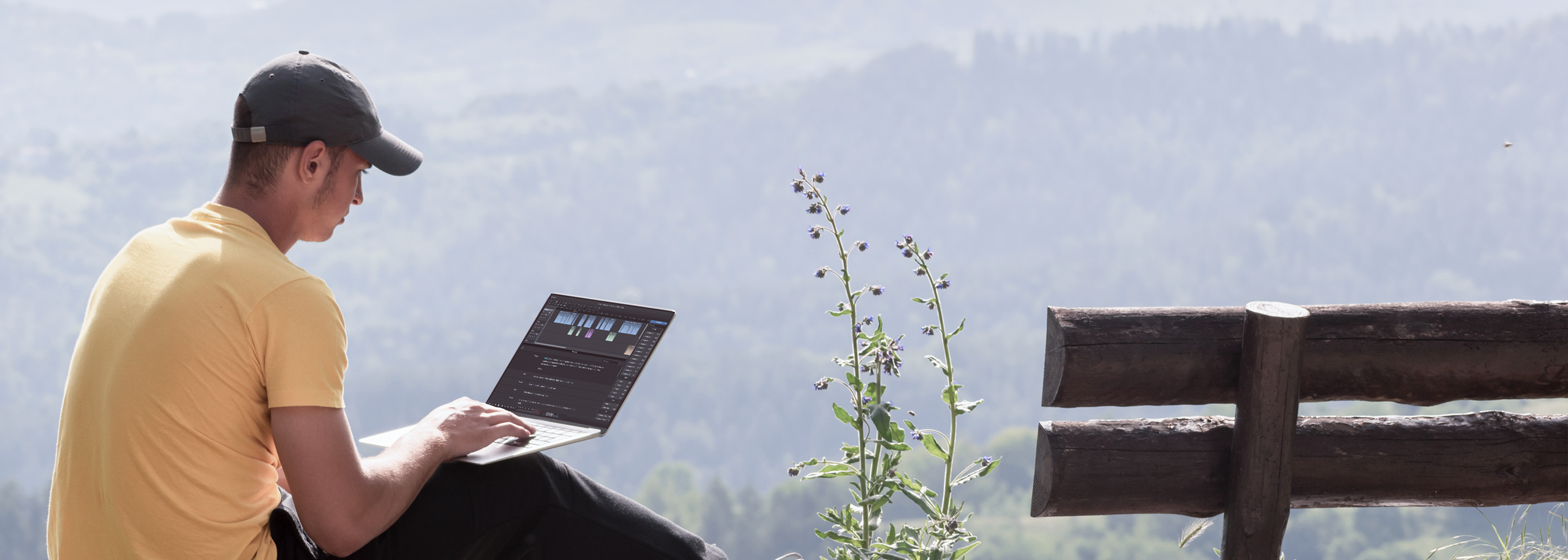 Man sitting next to a bench in summer forest landscape Editing Audio on Laptop in Hindenburg Pro Darkmode
